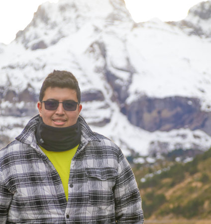 Latin man on vacation and mountains with snow in the backgroundの写真素材