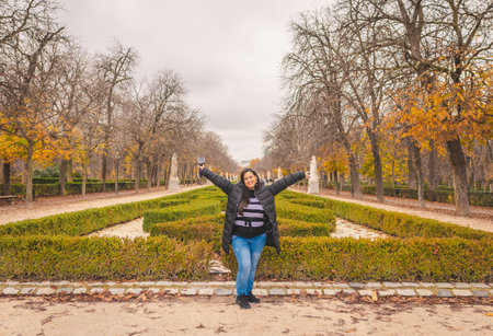 Latin woman in the green fields of Madrid's El Retiro Parkの写真素材