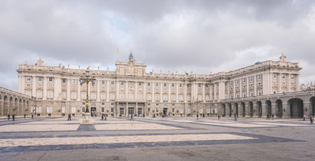 Royal Palace in Madrid, Spain with cloudy autumn sky and people in the backgroundの写真素材