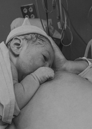 Newborn baby drinking breast milk for first timeの写真素材