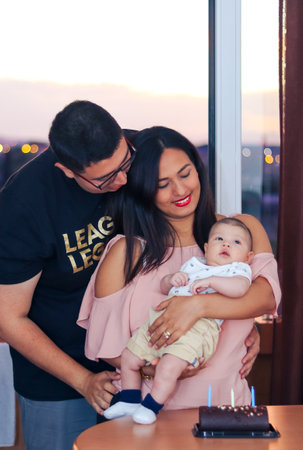 Young latin couple celebrating at home with their newborn baby