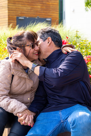 A married couple holding hands and laughing in a park.の写真素材