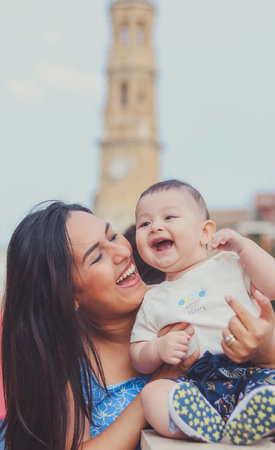 Mom with her baby happy, smiling and walking in the cityの写真素材
