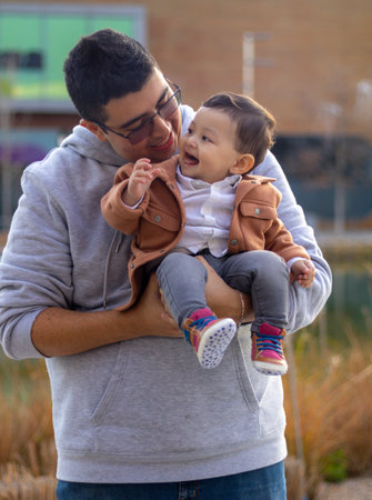 Dad with his happy baby, smiling, walking in a park