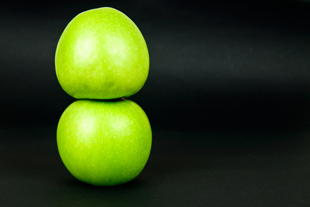 Two fresh healthy green apple on dark backgroundの写真素材