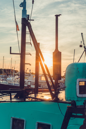 Sail Boats and motor boats moored in the harbor and dock with amazing view and nice sunset. Near sea and parts of fishing boats. Cruise and sea expeditions.の写真素材