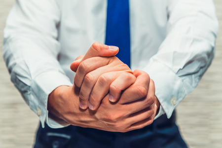 Businessman with crossed hands. Wanted to say something, make speech or waiting for something. Wearing white shirt and blue tie.の写真素材