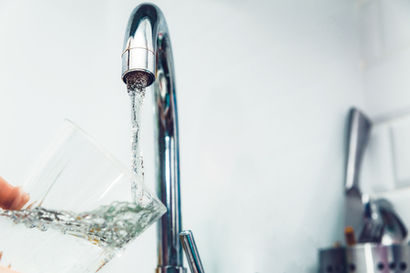 Tap from which the water flows. The price of water is rising. Water quenches thirst. Problems with water in some countries.The glass is filled with water.の写真素材