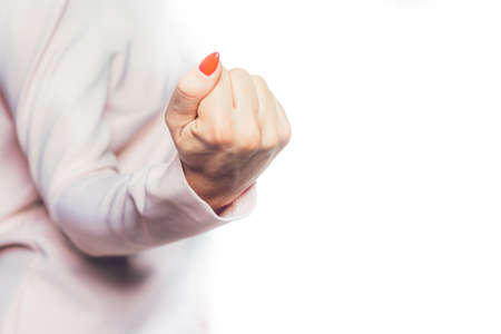 The hand shows the fist. A woman, a businesswoman shows her hand with a fist. An upset, stressed and...