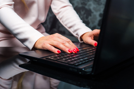 Working on a laptop, typing on a computer. Woman hands typing on a laptop. Woman working on a...