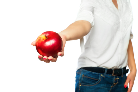 A woman in a white shirt holds an apple in her hand.の写真素材