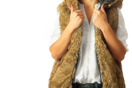 Fashion look on woman. Woman wearing a brown fur jacket and a white shirt.の写真素材