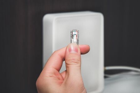 Internet cable, LAN cable kept in hand. A plug from an internet cable. Wifi and internet concept. Cable or wireless internet.の写真素材