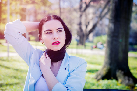 Portrait of a beautiful and cute girl with sunglasses. Close-up of the face of a woman looking down, focused. The sun's rays illuminate the hair of the female. Concept lifestyle outside.の写真素材