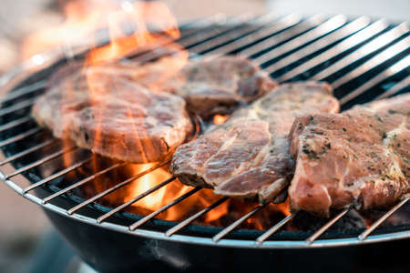 Steak on a charcoal grill with flamesの写真素材