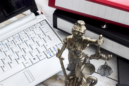 Law concept, statue, laptop and folder on wood tableの写真素材