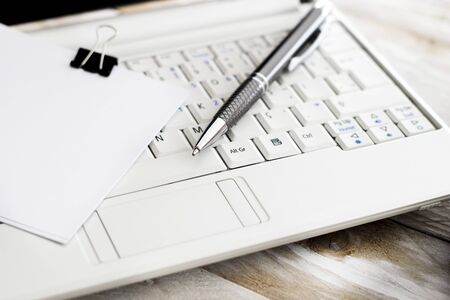 Office workplace with laptop and pen on wood tableの写真素材