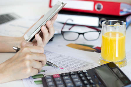 Businesswoman Analyzing and using graphic calculator in the office