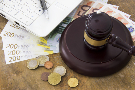 Labor law concept, laptop, gavel and money on wooden tableの写真素材