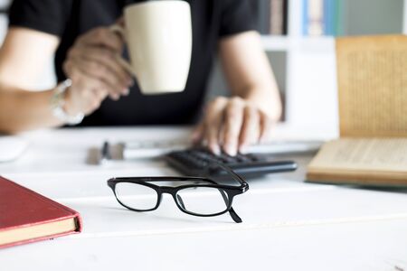 Businesswoman working with calculator in the office workplaceの写真素材