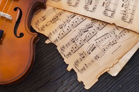 violin and music notes on wooden tableの写真素材