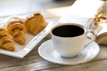 Croissants with coffee on the wooden tableの写真素材