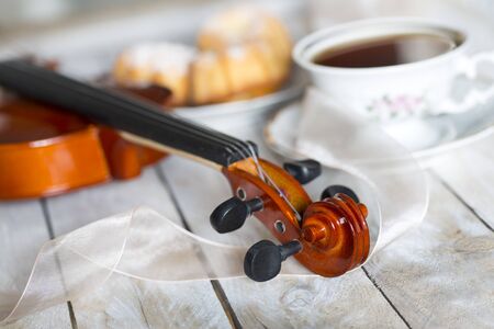 Coffee with cupcakes and violin on the wooden tableの写真素材