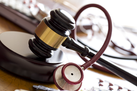 Medicine law concept. Judges gavel with stethoscope and pills close upの写真素材