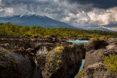 Beautiful Patagonian waterfall in a forest lit by the rising sun of Patagoniaの写真素材
