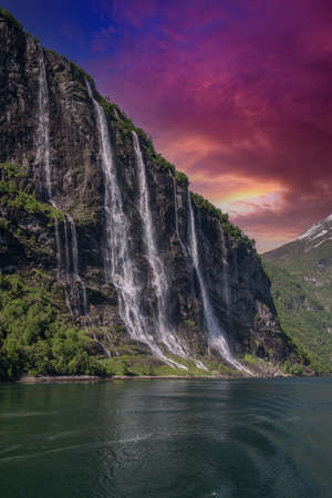 beautiful waterfalls with crystal clear water with mountains in the background at sunset Norway.の写真素材
