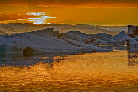 The sun sets over the famous glacier lagoon at Jokulsarlon, Iceland.