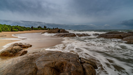 beautiful sunset with rocks in the foreground and huge waves in the background indian ocean sri lanka.の写真素材