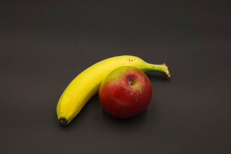 Banana and one red green appla isolatedの写真素材