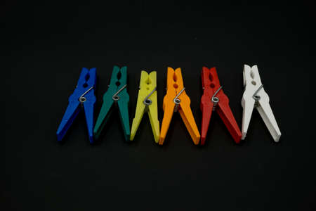 Clothes peg multicolor isolated on black backgroundの写真素材