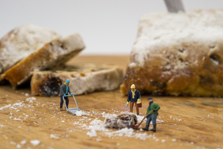 Miniature people shoveling snow from boardの写真素材