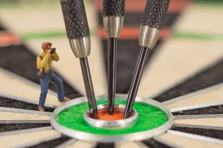 miniature people with dart in bull's eye, close up conceptの写真素材