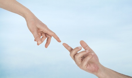 Touching fingers on sky backgroundの写真素材