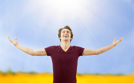 Young man spreading arms in natureの写真素材