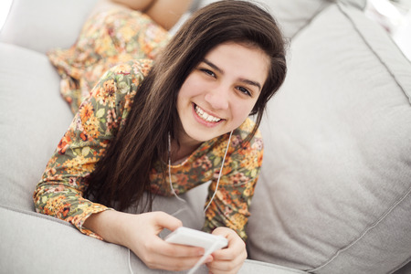 Teenage girl listening music through mobile phoneの写真素材