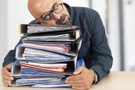 Sleeping businessman on tableの写真素材