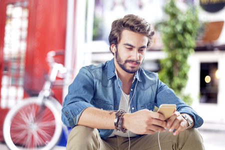 Young man using mobile phone in streetの写真素材