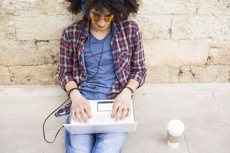 Young man using laptop and headphonesの写真素材