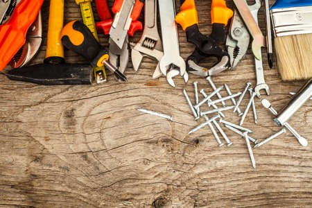 Assorted work tools on wood background