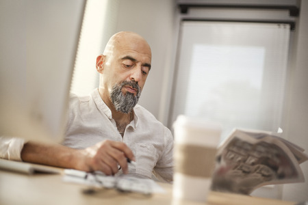 Portrait of businessman reading newspaperの写真素材