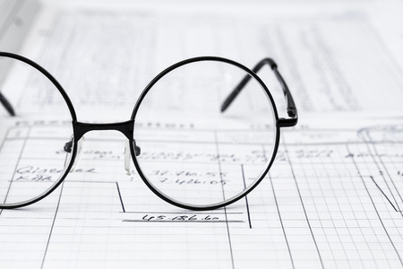 Paper with eyeglasses on tableの写真素材