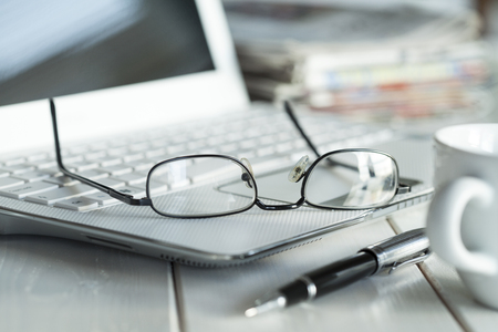Eyeglasses on laptop and coffeeの写真素材