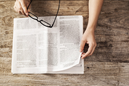 Young woman reading newspaperの写真素材