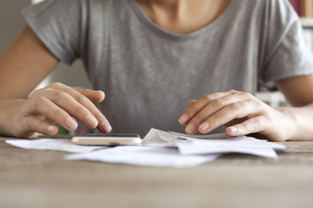 Woman hands with bills and mobile phoneの写真素材