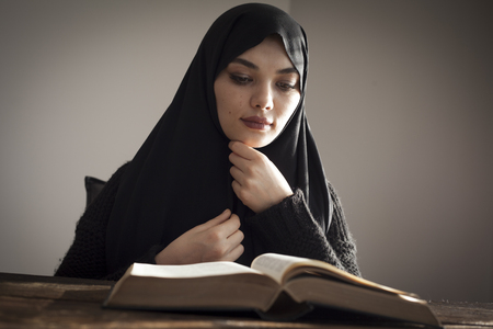 Muslim woman reading holy islamic book koranの写真素材