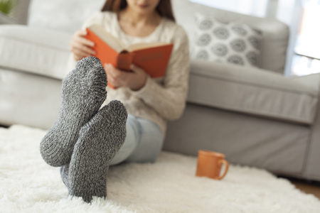 Young woman reading book in homeの写真素材